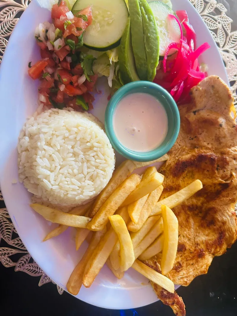 Delicious grilled chicken with rice, fries, and fresh salad.