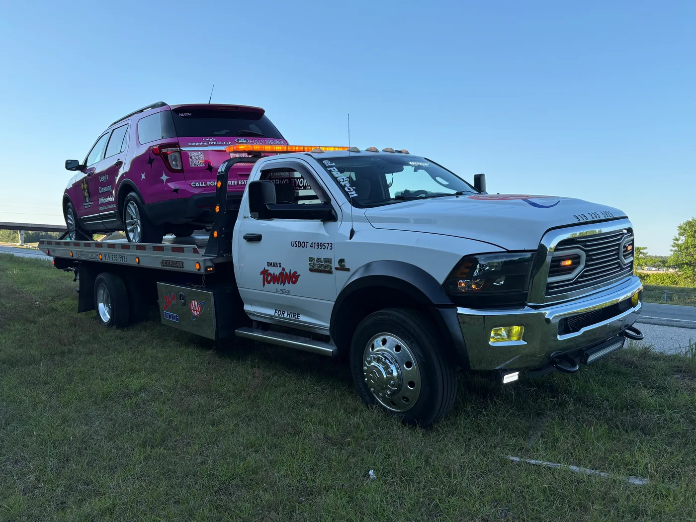 Omar’s Towing service truck in Raleigh, North Carolina with towed vehicle.