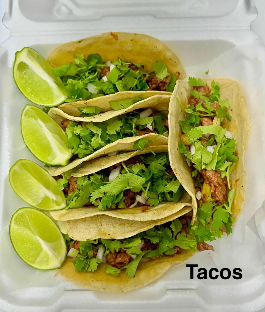 Tacos topped with cilantro and lime from D'Reyes Delicias food truck.
